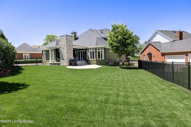 rear view of property featuring a lawn, a chimney, and fence