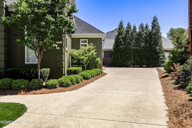 view of property exterior featuring stucco siding and a shingled roof