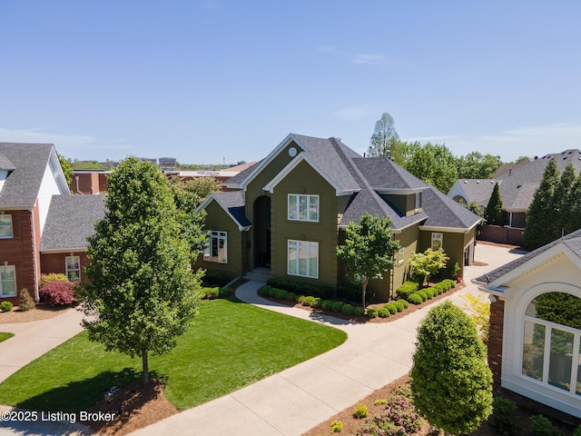 view of front of property with a shingled roof and a front lawn