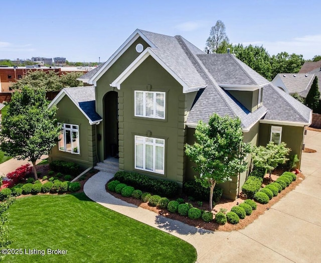 view of front of house featuring roof with shingles and a front lawn