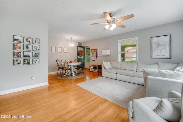 4203 Hewitt Ave, Louisville, KY 40220 - living room with light wood-style flooring, a ceiling fan, baseboards, and a chandelier