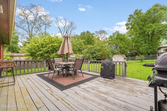 4203 Hewitt Ave, Louisville, KY 40220 - wooden deck featuring a storage shed, an outbuilding, outdoor dining space, area for grilling, and view of wooded area