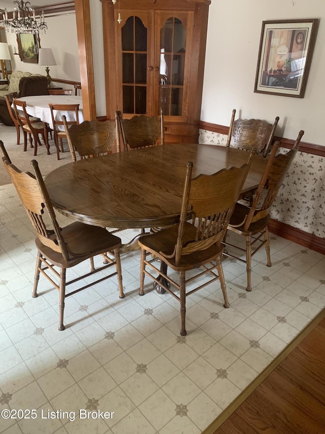 dining area with an inviting chandelier, light floors, and baseboards