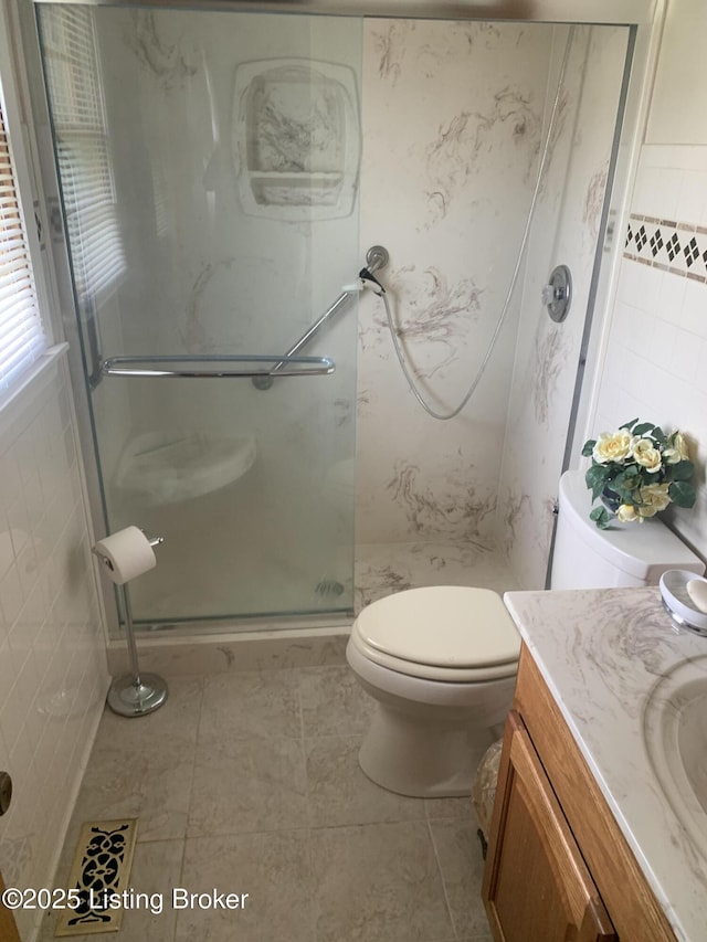 full bath with a shower stall, vanity, and toilet
