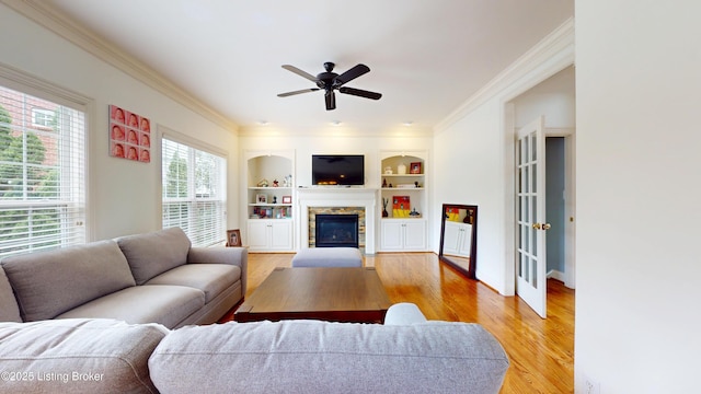 10513 Mountain Ash Ln, Prospect, KY 40059 - living area with ornamental molding, light wood-style flooring, a stone fireplace, ceiling fan, and built in shelves
