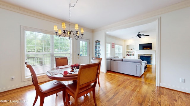 10513 Mountain Ash Ln, Prospect, KY 40059 - dining space featuring ornamental molding, a chandelier, a fireplace, light wood-style flooring, and baseboards