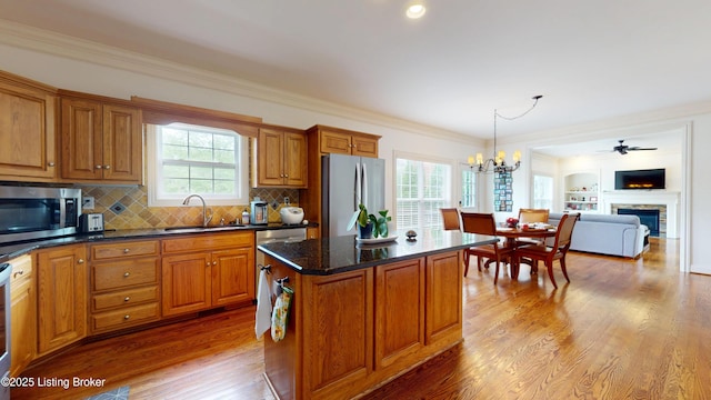 10513 Mountain Ash Ln, Prospect, KY 40059 - kitchen with stainless steel appliances, a sink, brown cabinetry, a chandelier, and wood finished floors