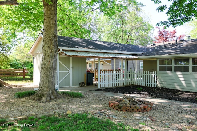 3101 Radiance Rd, Louisville, KY 40220 - rear view of house with a fire pit, fence, roof with shingles, an outdoor structure, and a storage shed