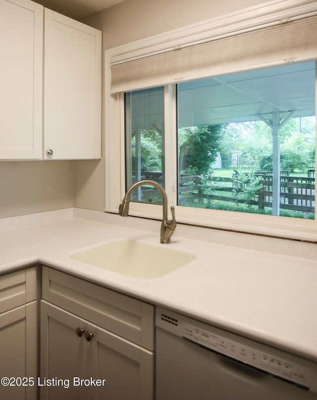 3101 Radiance Rd, Louisville, KY 40220 - kitchen featuring dishwashing machine, a sink, light countertops, and white cabinets