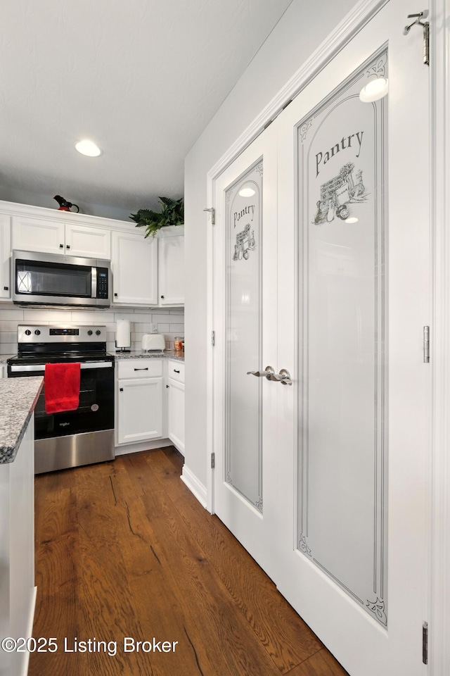 105 Hollow Springs Dr, Bardstown, KY 40004 - kitchen with appliances with stainless steel finishes, white cabinetry, dark wood-type flooring, decorative backsplash, and light stone counters