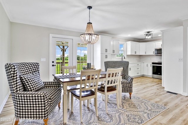 dining room featuring ornamental molding, light wood-type flooring, visible vents, recessed lighting, and an inviting chandelier