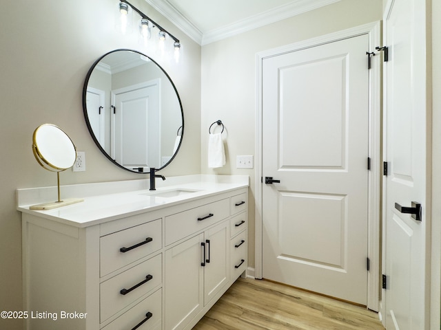 bathroom featuring crown molding, wood finished floors, and vanity