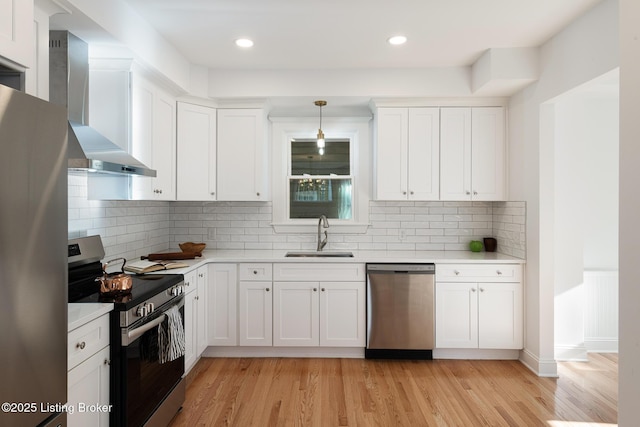 1245 S 7th St, Louisville, KY 40203 - kitchen with appliances with stainless steel finishes, a sink, wall chimney range hood, light countertops, and white cabinets