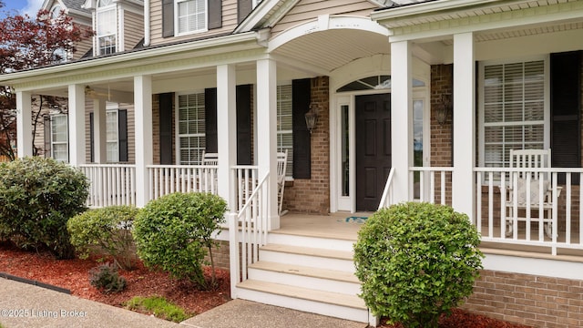 property entrance with brick siding and covered porch