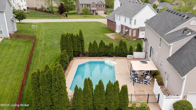 exterior space featuring a lawn, a residential view, a fenced in pool, and a fenced backyard