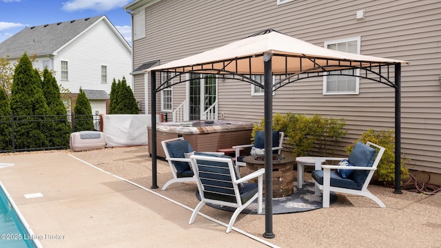 view of patio / terrace featuring a gazebo, a hot tub, and fence
