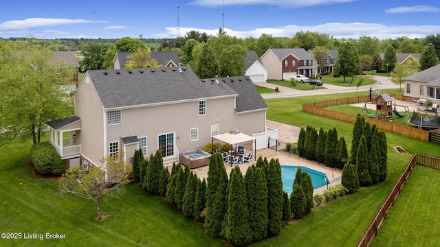 back of property featuring a yard, roof with shingles, a residential view, and a fenced backyard