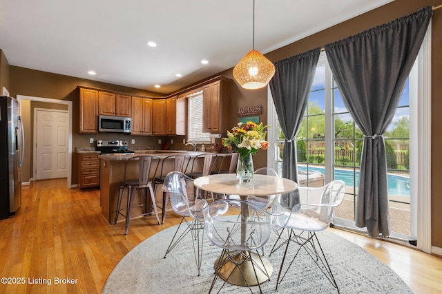 dining space with light wood-style flooring and recessed lighting