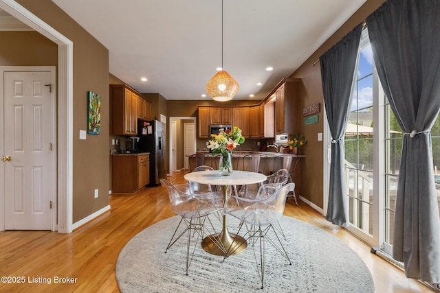 dining area featuring baseboards, light wood-type flooring, and recessed lighting