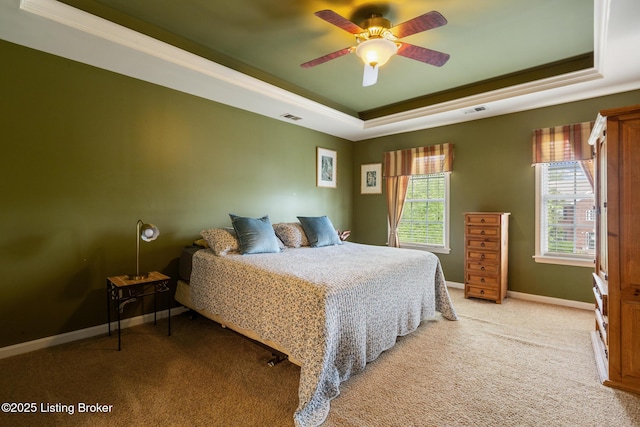 bedroom with baseboards, a raised ceiling, light carpet, and visible vents