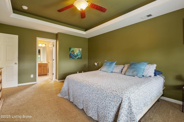 bedroom featuring light colored carpet, a raised ceiling, and visible vents