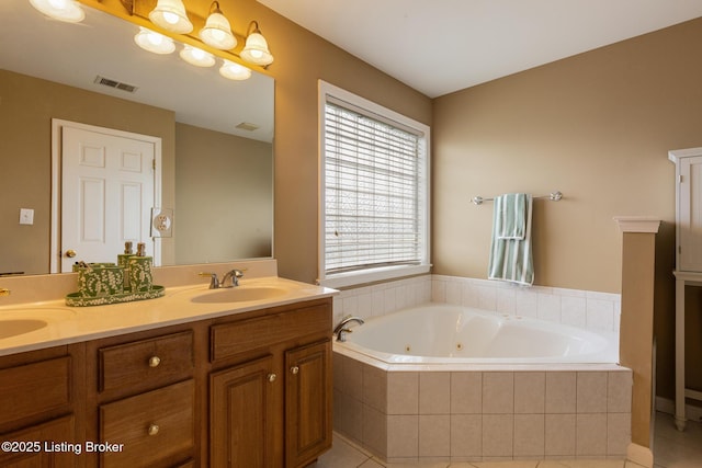 full bath featuring visible vents, a sink, tile patterned flooring, a jetted tub, and double vanity