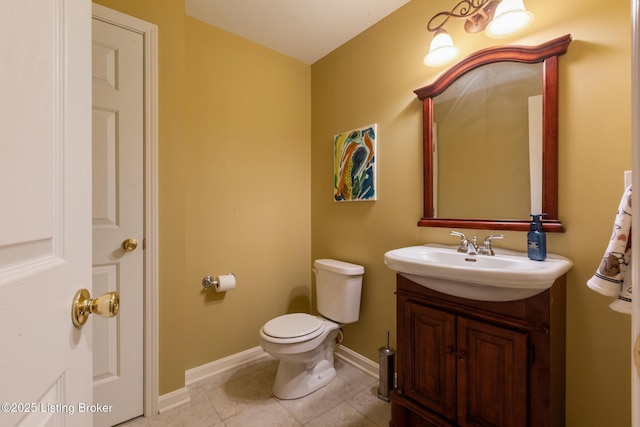 bathroom featuring toilet, tile patterned flooring, vanity, and baseboards