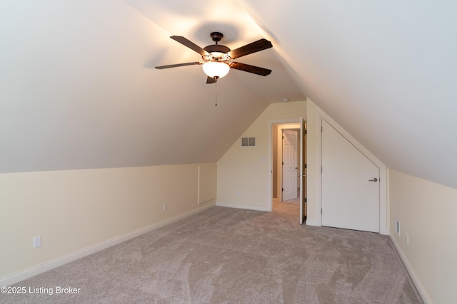 bonus room with light colored carpet, lofted ceiling, a ceiling fan, and baseboards