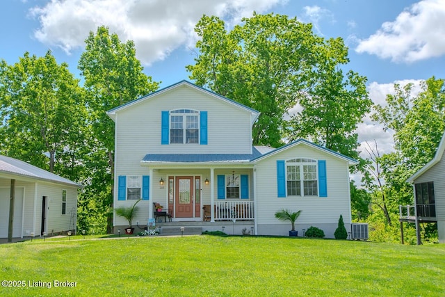 traditional-style home featuring covered porch, cooling unit, a front lawn, and metal roof