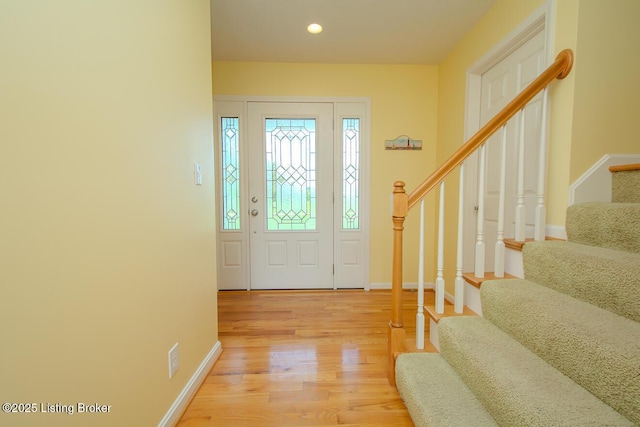 foyer with stairway, light wood-style floors, baseboards, and recessed lighting