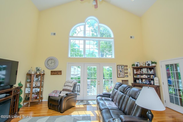 living room featuring high vaulted ceiling, wood finished floors, ceiling fan, and french doors