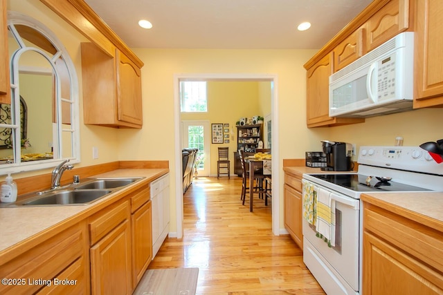 kitchen featuring white appliances, a sink, light wood-type flooring, light countertops, and recessed lighting