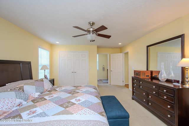 bedroom with light colored carpet, a closet, and ceiling fan