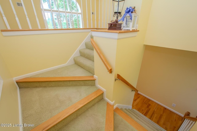 staircase featuring carpet flooring and baseboards