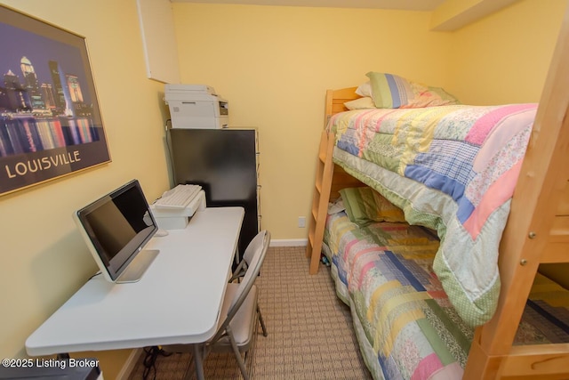 carpeted bedroom with a desk and baseboards