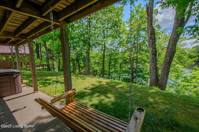 view of grassy yard featuring a hot tub and a patio area