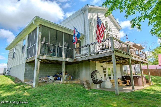 back of property with a wooden deck, a sunroom, a hot tub, and a patio