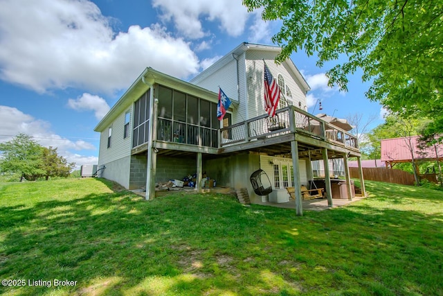 rear view of house featuring a sunroom, a wooden deck, a patio, and a jacuzzi