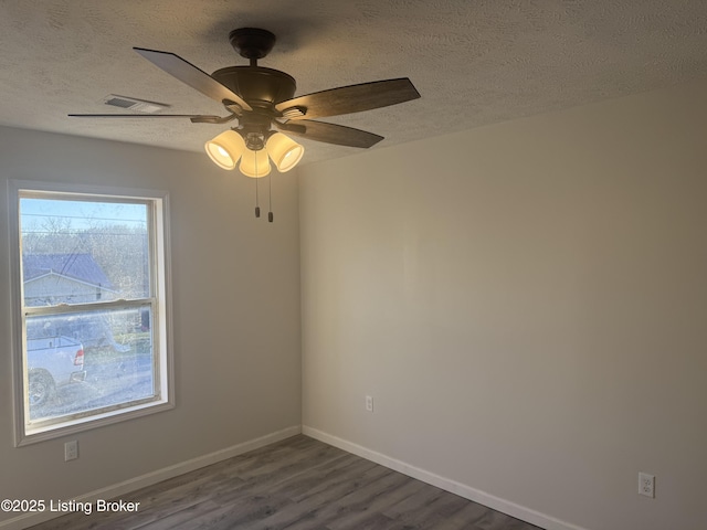 525 Leavette Ave, Leitchfield, KY 42754 - spare room featuring dark wood finished floors, a textured ceiling, baseboards, and ceiling fan