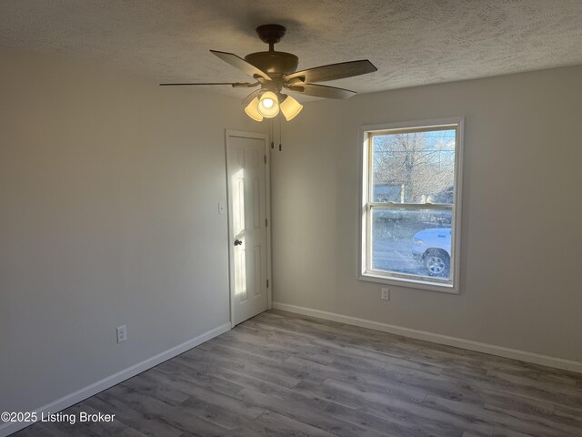 525 Leavette Ave, Leitchfield, KY 42754 - spare room with wood finished floors, a textured ceiling, baseboards, and a ceiling fan