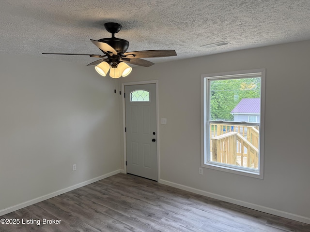 525 Leavette Ave, Leitchfield, KY 42754 - foyer entrance with a textured ceiling, plenty of natural light, wood finished floors, baseboards, and a ceiling fan