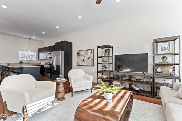 living area featuring wood finished floors, baseboards, ceiling fan, and recessed lighting