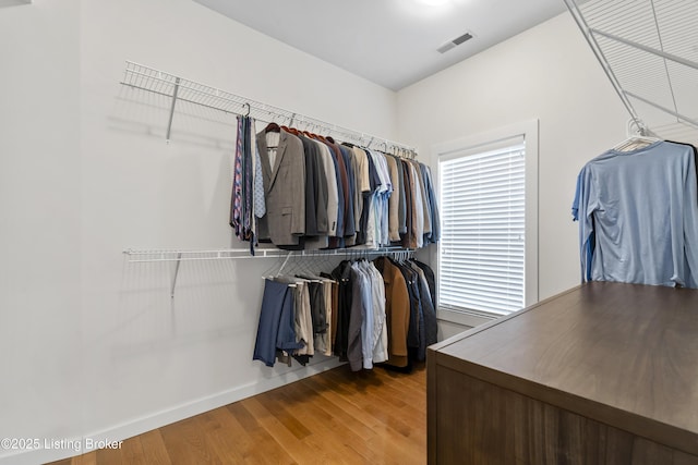 walk in closet with visible vents and wood finished floors
