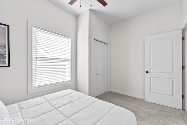 bedroom with carpet flooring, a closet, baseboards, and ceiling fan