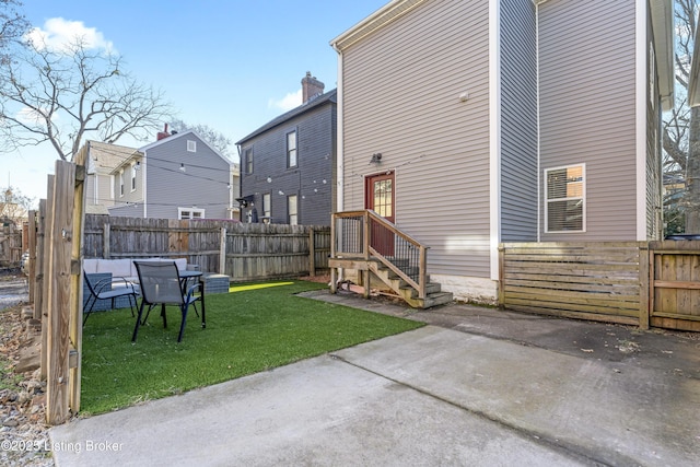back of house featuring a patio area, a lawn, and a fenced backyard