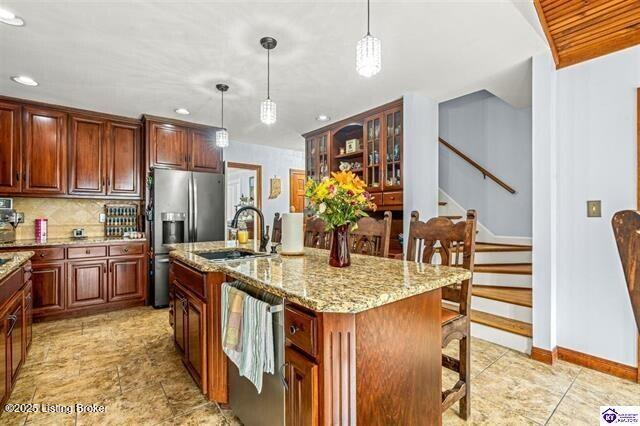 3507 Bridgegate Ct, Louisville, KY 40272 - kitchen with appliances with stainless steel finishes, a sink, a kitchen bar, light stone countertops, and recessed lighting