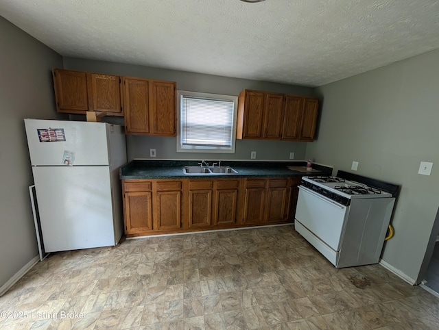 511 Marret Ave, Louisville, KY 40208 - kitchen featuring white appliances, a sink, brown cabinets, dark countertops, and a textured ceiling