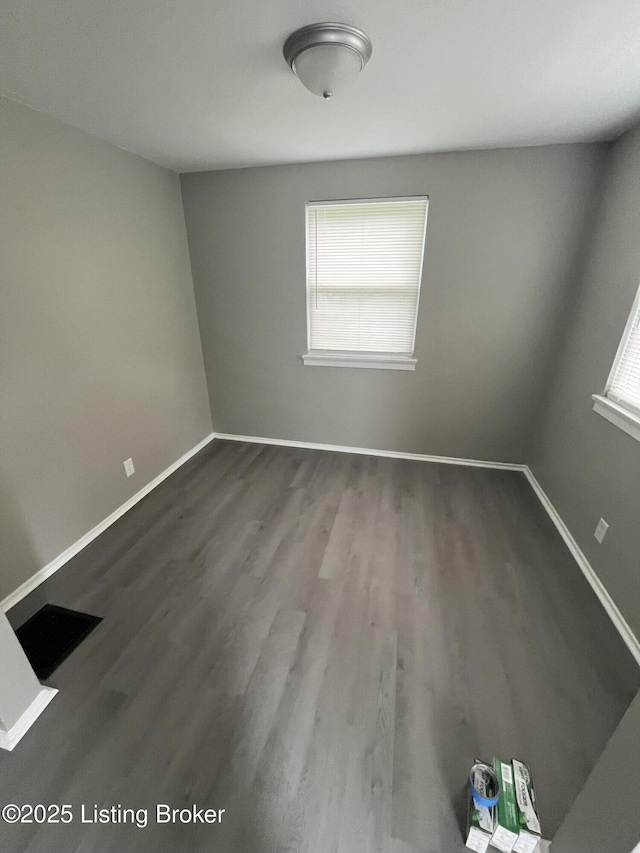 unfurnished room featuring baseboards and wood finished floors