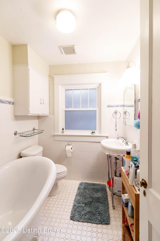 2104 Lauderdale Rd, Louisville, KY 40205 - full bathroom with tile walls, toilet, visible vents, a sink, and a freestanding tub