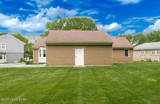 4002 Ciremos Ter, Louisville, KY 40241 - rear view of house with a yard, brick siding, a chimney, and central AC